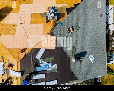 Am Apartmentgebäude wurden Dachreparaturen durchgeführt, wobei das alte Dach durch neue Schindeln ersetzt wurde Stockfoto