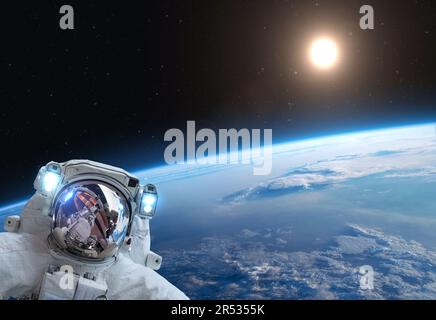 Astronaut auf dem Raumschiff über dem blauen Planeten Erde. Science-Fiction-Tapete. Elemente dieses Bildes, bereitgestellt von der NASA Stockfoto