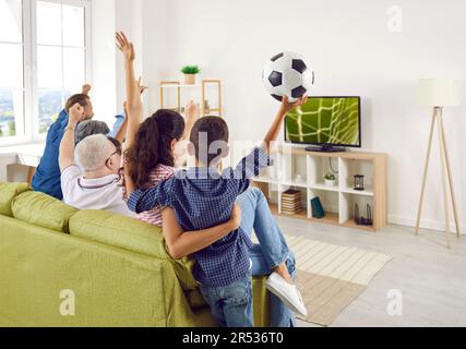 Aufgeregte glückliche große Familie jubelt beim American Football Championship Spiel im Fernsehen. Stockfoto