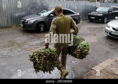 Zaporischschien, Ukraine. 30. Mai 2023. Ein ukrainischer Soldat wird mit Tarnnnnetzen gesehen, die in einem Freiwilligenzentrum in Zaporischzhien hergestellt wurden. Seit dem ersten Kriegstag ist Zaporischhien zu einem Haufen von Aktivitäten für Freiwillige geworden, die alles von Körperpanzerung über Tarnnetze, Panzerabwehrbarrieren bis hin zu Heizöfen und Gewehrschlingen für ukrainische Soldaten, die die russische Invasion bekämpfen, produzieren. (Kreditbild: © Andriy Andriyenko/SOPA Images via ZUMA Press Wire) NUR REDAKTIONELLE VERWENDUNG! Nicht für den kommerziellen GEBRAUCH! Stockfoto