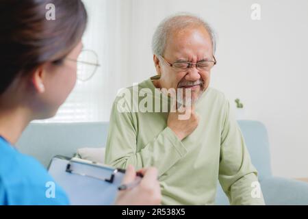 Junger Arzt untersucht Seniorenpatienten beim Hausbesuch Stockfoto