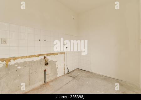 Ein unvollendeter Raum mit weißen Fliesen an den Wänden und einem Loch in der Wand, das abgestrichen wurde Stockfoto
