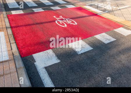 Kreuzung in der Stadt. Radweg neben Fußgängerübergang auf der Straße. Auf Asphalt angebrachtes Fahrradabzeichen Stockfoto