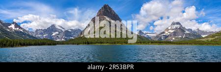 Frühling am Swiftcurrent Lake - Panoramablick auf den Swiftcurrent Lake, mit zerklüfteten Gipfeln an der Küste, an einem Frühlingsmorgen. Glacier-Nationalpark, MT. Stockfoto