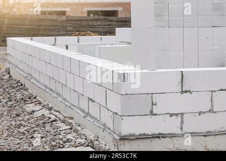 Bau von Porenbeton. Unfertige Hauswand aus weißem, autoklaviertem Betonblock mit Porenbelüftung Stockfoto