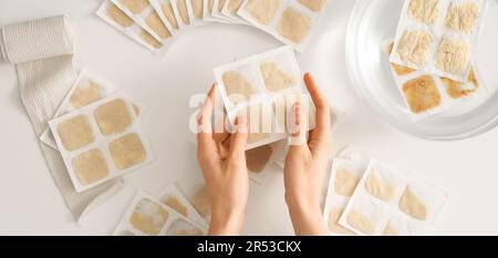 Hände und viele Senfpflaster auf weißem Hintergrund, Draufsicht Stockfoto