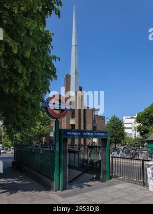 LONDON, Großbritannien - 27. MAI 2023: Blick auf den Eingang zur U-Bahn-Station Warwick Avenue mit der St Saviour's Church im Hintergrund Stockfoto