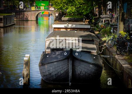 Hausboote und alte Brücke über einen der Kanäle im zentralen Bezirk, Amsterdam, Holland Stockfoto