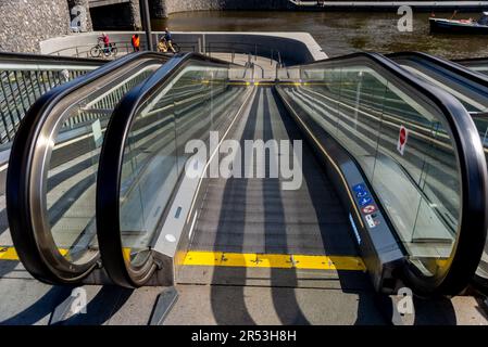 Rolltreppe führt zu einem unterwasserenen Fahrradparkplatz in der Nähe des Amsterdamer Hauptbahnhofs, Niederlande Stockfoto