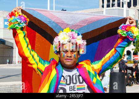 asiatischer Mann in Regenbogenanzug und Flagge mit Armen oben am Birmingham LGBTQ Gay Pride Samstag, den 27. 2023. Mai Stockfoto