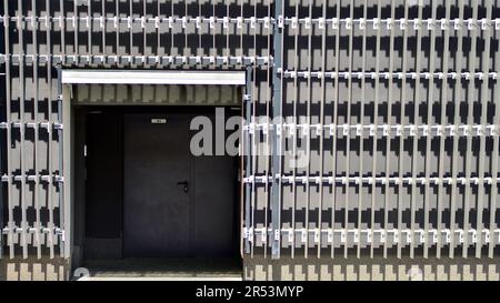 Metallfassade des Gebäudes. Details der Aluminiumfassade und der Aluminiumpaneele am Gebäude. Verkleidungsplatten aus Stahlrahmen. Stockfoto