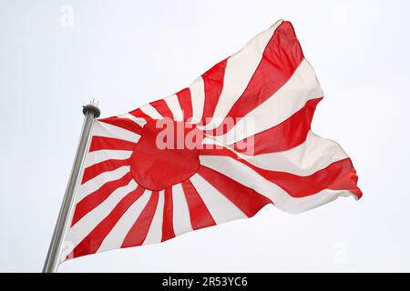 Japanische aufsteigende Sonnenfahne im Wind des Himmels Stockfoto