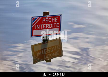 Schild, das aus dem Wasser springt und auf Französisch „Pêche interdite“ bedeutet, was auf Englisch „Fischen verboten“ bedeutet. Stockfoto