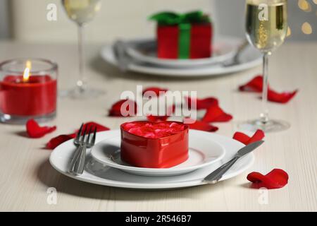 Wunderschöne Tischgestaltung mit dekorativem, herzförmigem Kasten mit Rosen für romantisches Abendessen, Nahaufnahme Stockfoto