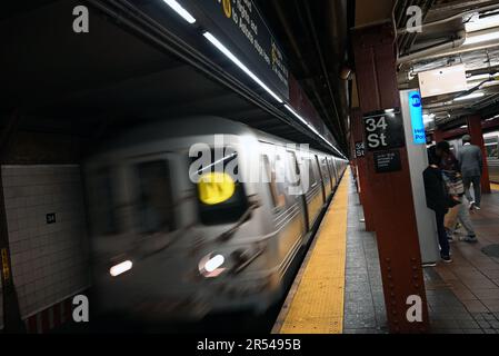 Ein U-Bahn-Zug, der zur MTA-Station in der 34. Straße in New York City fährt. Stockfoto