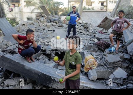 Gaza, Palästina. 31. Mai 2023. Palästinensische Kinder, die nach israelischen Anschlägen auf Gaza-Stadt in den Trümmern ihrer zerstörten Wohngebäude spielten. Israel und die islamische Dschihad-Bewegung einigten sich Ende Mai auf einen von Ägyptern vermittelten Waffenstillstand. Israel hat als Reaktion auf den Abschuss von Raketen vom Gazastreifen nach Israel mehrere Angriffe auf die militärische Führung der palästinensischen Islamischen Dschihad-Bewegung verübt. Die Auswirkungen der israelischen Razzien auf Gaza am 12. Mai 2023. Kredit: SOPA Images Limited/Alamy Live News Stockfoto