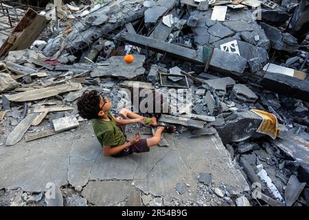 Gaza, Palästina. 31. Mai 2023. Ein palästinensisches Kind spielt inmitten der Trümmer seiner zerstörten Wohngebäude nach israelischen Anschlägen auf Gaza City. Israel und die islamische Dschihad-Bewegung einigten sich Ende Mai auf einen von Ägyptern vermittelten Waffenstillstand. Israel hat als Reaktion auf den Abschuss von Raketen vom Gazastreifen nach Israel mehrere Angriffe auf die militärische Führung der palästinensischen Islamischen Dschihad-Bewegung verübt. Die Auswirkungen der israelischen Razzien auf Gaza am 12. Mai 2023. (Foto: Mahmoud Issa/SOPA Images/Sipa USA) Guthaben: SIPA USA/Alamy Live News Stockfoto