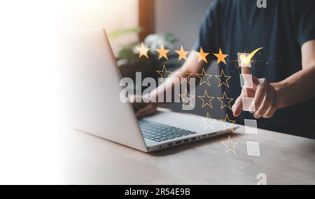 Bewertung mit 5 Sternen bei einem Geschäftsmann, der ein Notebook benutzt. Bewertung und Zufriedenheit des Kundendienstes. Top Service, ISO-Zertifizierung, Garantie, Qualität Stockfoto