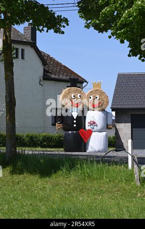 St. Vith, Belgien. 28. Mai 2023. Braut und Bräutigam aus Heuballen oder Strohballen stehen vor einem Haus am Straßenrand. Credit: Horst Galuschka/dpa/Horst Galuschka dpa/Alamy Live News Stockfoto