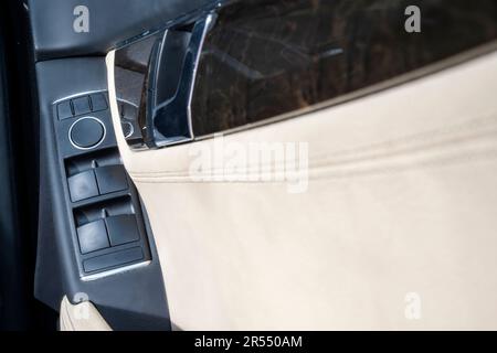 Kfz-Türverkleidungen mit beigefarbenem Lederinnenraum. Moderne Autotür Stockfoto