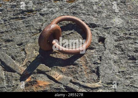 Verlegung eines alten, rostigen Metallankerrings für Schiffe, die in einem Fels fixieren. Stockfoto