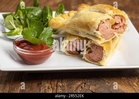 Würstchen In Blätterteig Mit Salat Stockfoto