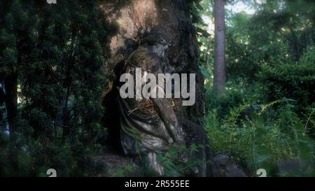 Skulptur einer schönen trauernden Frau auf einem Friedhof. Sie lehnt sich auf einen unangebrachten Stein. Stockfoto