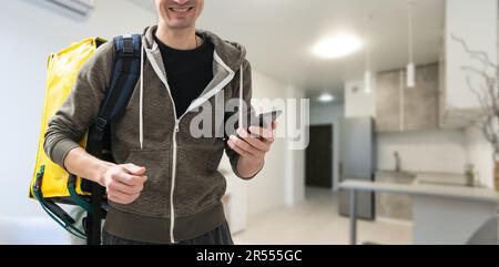 Liefermann mit Thermal-Rucksack für Essen. Essenslieferung zum Mitnehmen. Mann liefert online Lebensmittelbestellungen an Kunden mit Thermosack, Lebensmittellieferung. Stockfoto