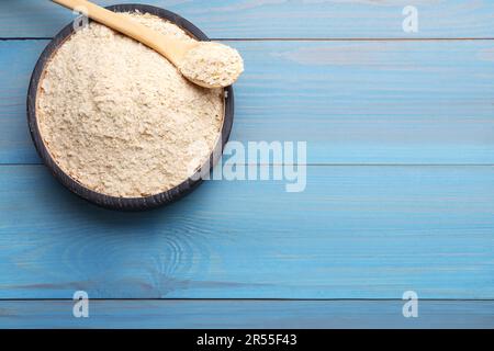 Schüssel mit Hefeflocken der Brauerei auf hellblauem Holztisch, Draufsicht. Platz für Text Stockfoto