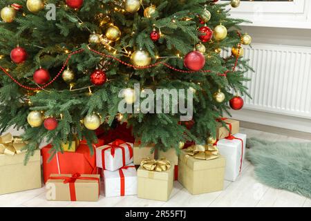 Schöner Weihnachtsbaum und viele Geschenke im Haus Stockfoto