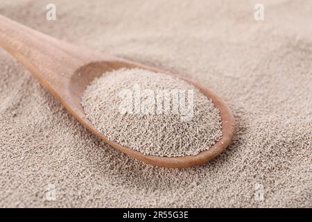 Löffel auf Stapel aktiver Trockenhefe, Nahaufnahme Stockfoto