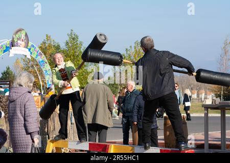 Bendery, Moldawien - 12. November 2022: Log Fight Game. Festlichkeiten während der Feiertage Maslenitsa. Ziel des Spiels ist es, den anderen vom zu stoßen Stockfoto