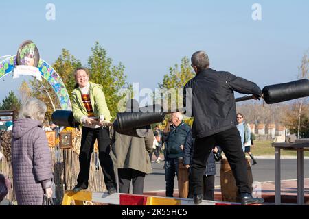 Bendery, Moldawien - 12. November 2022: Log Fight Game. Festlichkeiten während der Feiertage Maslenitsa. Ziel des Spiels ist es, den anderen vom zu stoßen Stockfoto