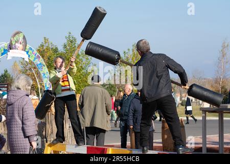 Bendery, Moldawien - 12. November 2022: Log Fight Game. Festlichkeiten während der Feiertage Maslenitsa. Ziel des Spiels ist es, den anderen vom zu stoßen Stockfoto