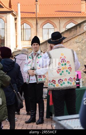 Bendery, Moldawien - 12. November 2022: Männer in moldauischen Nationalanzügen - Schafshüte (Căciulă), Pieptar (ist eine bestickte Schafshaut-Weste) und Nati Stockfoto