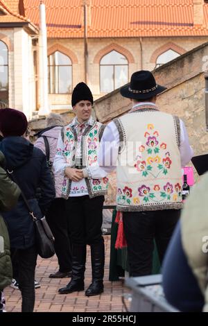 Bendery, Moldawien - 12. November 2022: Männer in moldauischen Nationalanzügen - Schafshüte (Căciulă), Pieptar (ist eine bestickte Schafshaut-Weste) und Nati Stockfoto