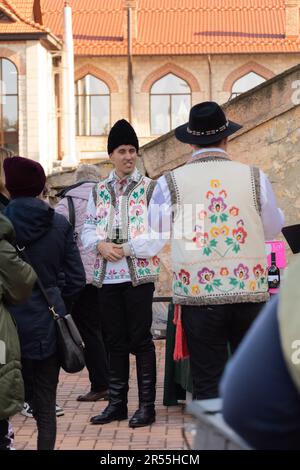 Bendery, Moldawien - 12. November 2022: Männer in moldauischen Nationalanzügen - Schafshüte (Căciulă), Pieptar (ist eine bestickte Schafshaut-Weste) und Nati Stockfoto