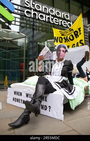 London, England, Großbritannien 01/06/2023 Money Rebellion Aktivisten veranstalten bei Standard Chartered eine satirische „Menage a trois“ zwischen dem CEO Bill Winters und seinen fossilen Brennstofffreunden, Öl und Kohle, während Rishi Sunak Champagner serviert und gelegentlich mit einem Haufen Geld angeboten wird. Stockfoto