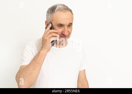 Älterer, reifer Rentner, der sich verzweifelt fühlt, am Telefon telefoniert, Probleme hat, Schulden, gestresster, trauriger Mann mittleren Alters, deprimiert durch schlechtes Hören Stockfoto