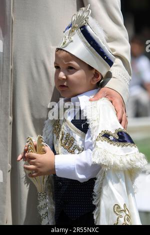 Vor seiner zeremonie im sunnet (Beschneidung) steht vor dem Eyup Sultan Camii in Istanbul in Turkiye ein wunderschön gekleideter türkischer Junge. Stockfoto