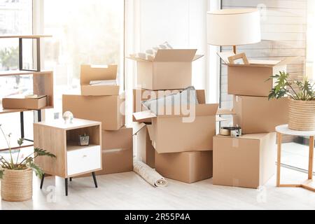 Pappe, Umzugskartons und Packhaus mit Möbeln, Wohnzimmerdekorationen und Wohnraum. Haushalt, verpackter Karton und leeres Grundstück zu Stockfoto