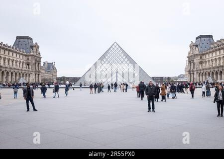 Die berühmte Louvre-Pyramide und das elegante Palais Royale stehen an einem ruhigen grauen Frühlingstag in Paris, Frankreich, Seite an Seite. Inmitten einer belebten Menschenmenge von Besuchern und Touristen verbinden diese architektonischen Meisterwerke Modernität und Geschichte und laden zu Entdeckungen und Wertschätzung ein. Erleben Sie die harmonische Mischung aus Alt und Neu, während das reiche kulturelle Erbe der Stadt inmitten der pulsierenden Energie eines beliebten Reiseziels zum Leben erwacht. Stockfoto