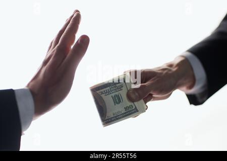 Die Männerhand gibt dem Geld noch eine Hand auf weißem Hintergrund. Stockfoto