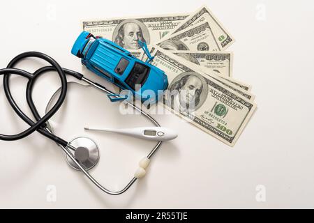 Notfalldiagnose. Hohe Preise für Krankenwagen. Weißes Auto auf einem Haufen Dollar neben rotem Fragezeichen und Stethoskop Stockfoto