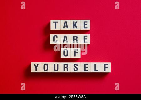 Passen Sie auf sich auf - Wortkonzept auf Würfeln, Text Stockfoto