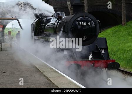 Besuch der BR Standard Klasse 4 Nr. 75014 Braveheart beim Wassertrinken an der Cheltenham Rennbahn Station während des GWSR Cotswold Festival of Steam 2023. Stockfoto