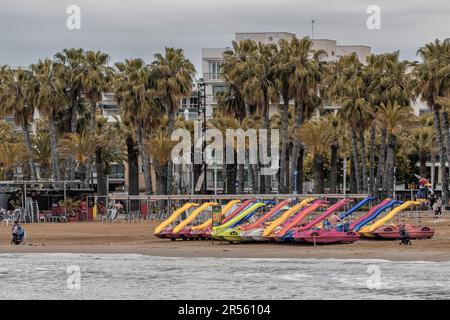 Tretboote mit Rutsche liegen am Strand von Poniente in der Stadt Salou, Costa Daurada, Provinz Tarragona, Katalonien, Spanien, Europa Stockfoto