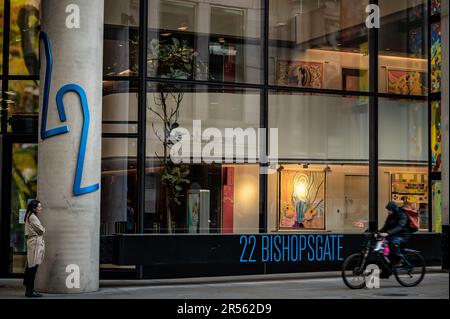 London, Vereinigtes Königreich: 22 Bishopsgate oder Twentytwo in der City of London. Zeigt die Vorderseite des Gebäudes auf Straßenebene mit einer stehenden Frau und einem Radfahrer. Stockfoto