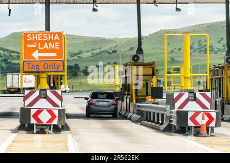 Auto- und Autofahrer zahlen für die mautgebühren an der mautstelle in Südafrika Konzepttechnologie, Infrastruktur und Transport in Afrika Stockfoto