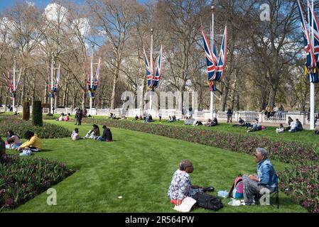 London, Vereinigtes Königreich - 04 07 2023: Die Menschen ruhen sich im Memorial Garden neben dem Buckingham Palace in London aus. Stockfoto